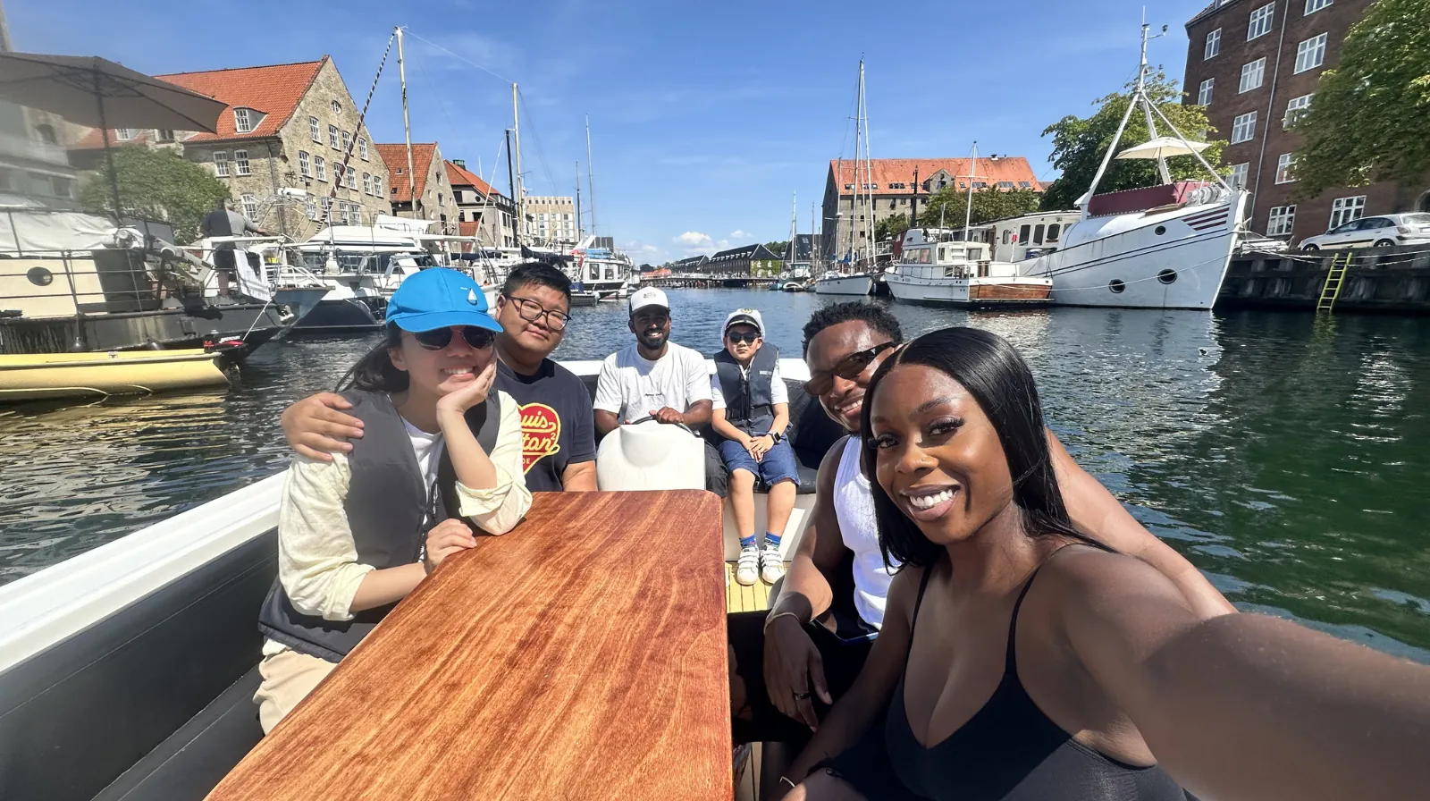 A group on board taking a selfie in a quiet canal