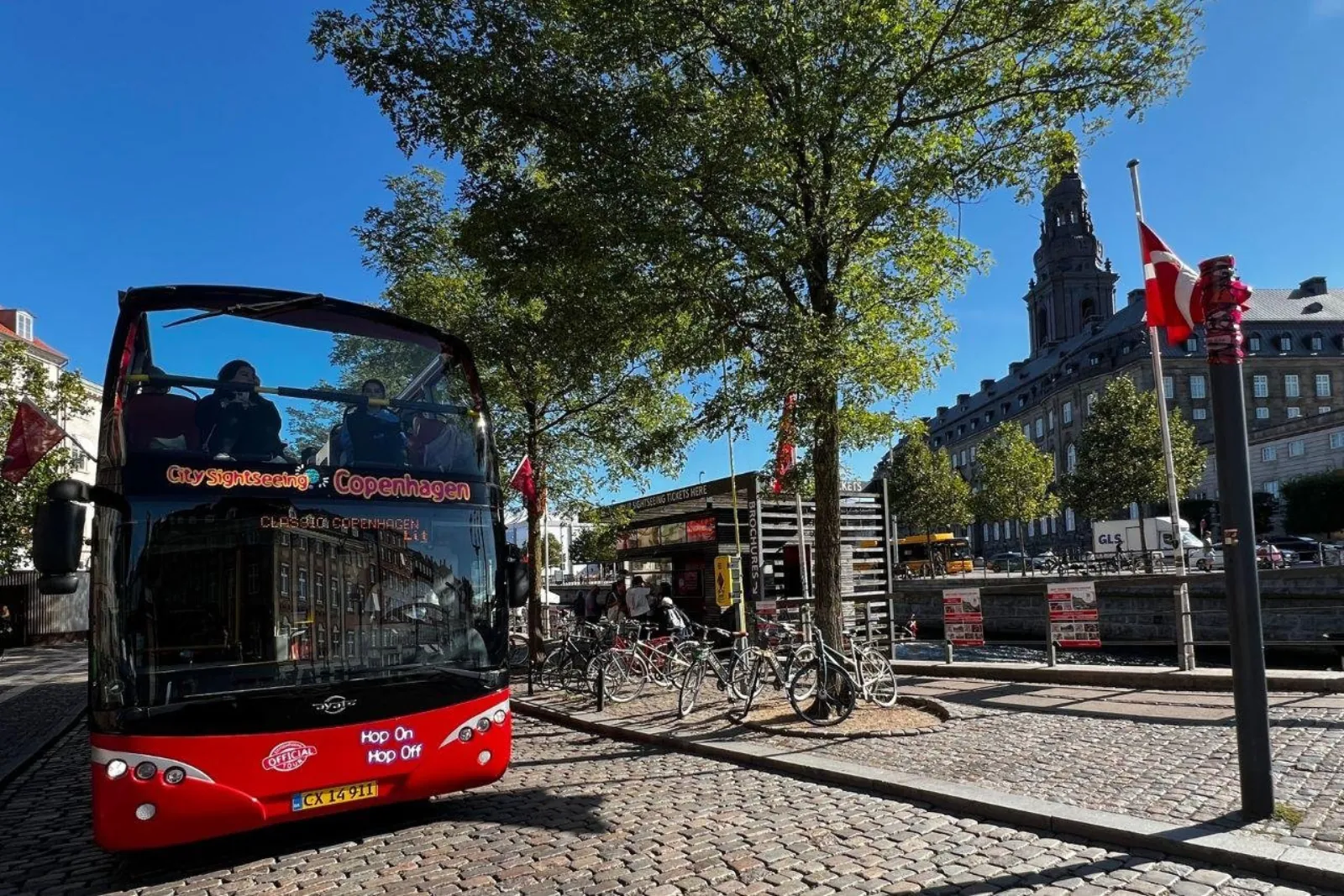 A red double-decker sightseeing bus in the city