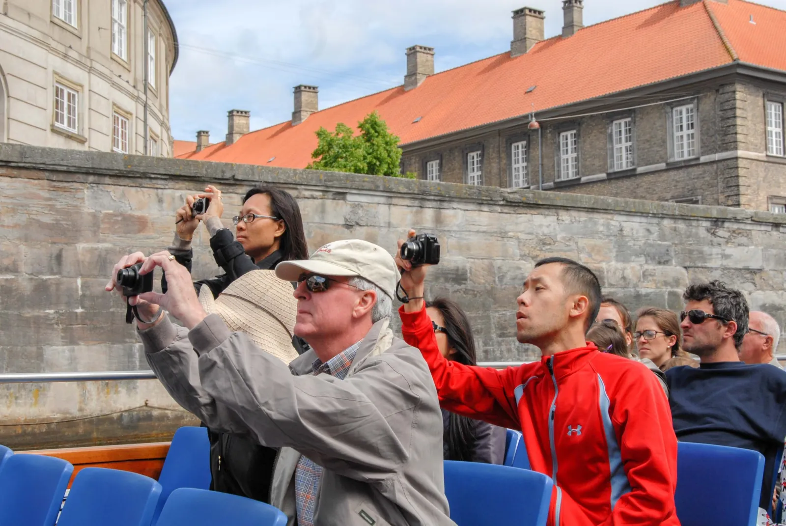Passengers photographing the sights from a canal boat