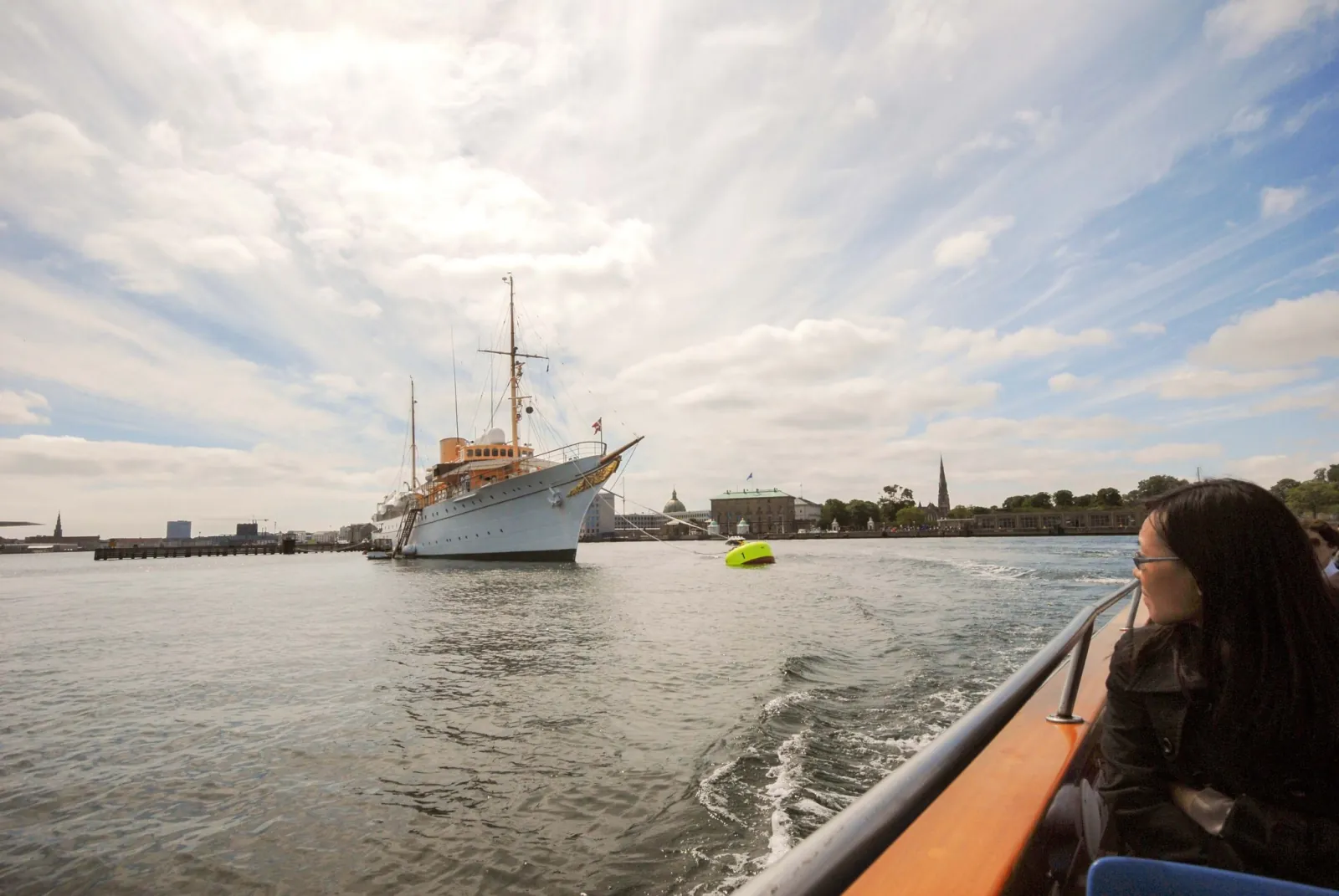 A white sailing ship at anchor seen from the boat