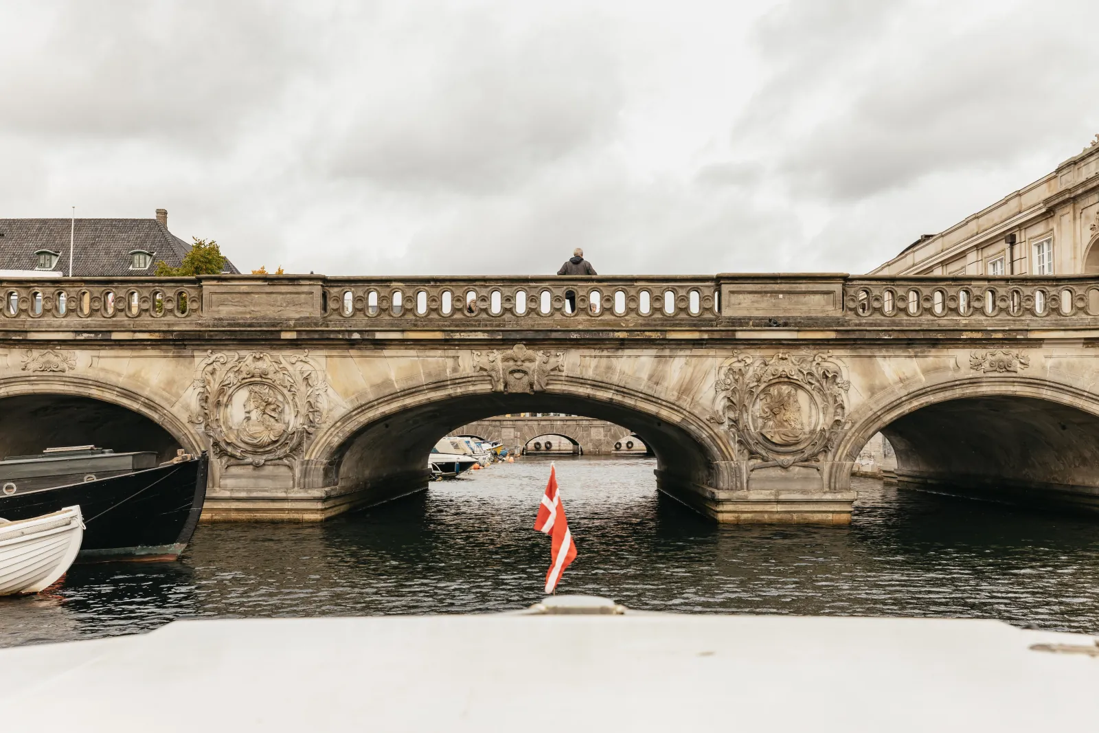 An arched stone bridge seen from the bow of a canal boat