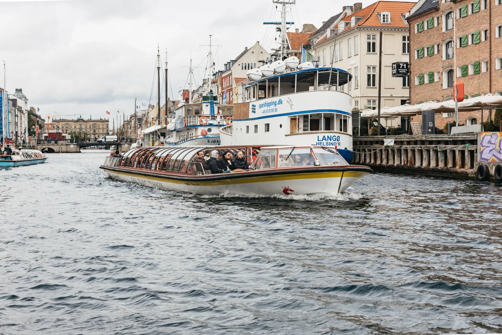 A canal tour boat sailing out of Nyhavn