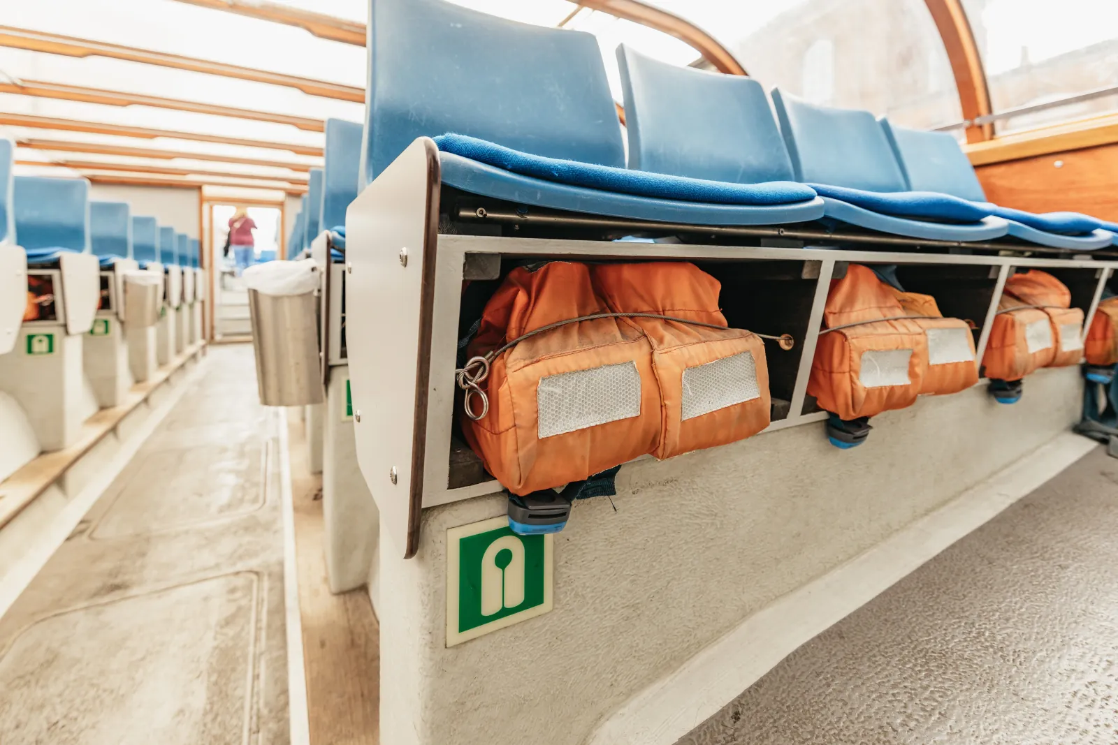 Life jackets stowed under the seats inside a covered canal boat