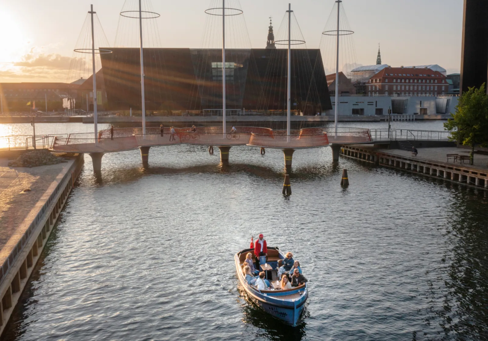 The electric boat passing old ships and a timber quay