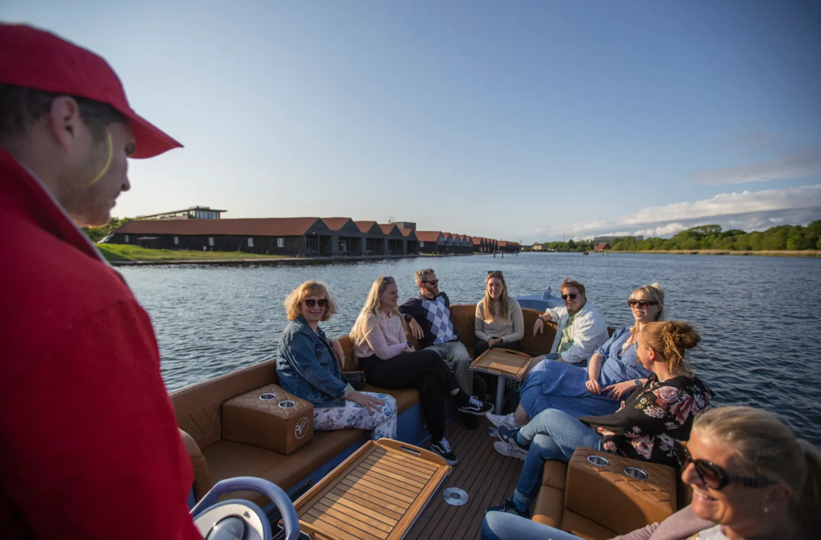 The guide in a red cap talking to a full boat of guests