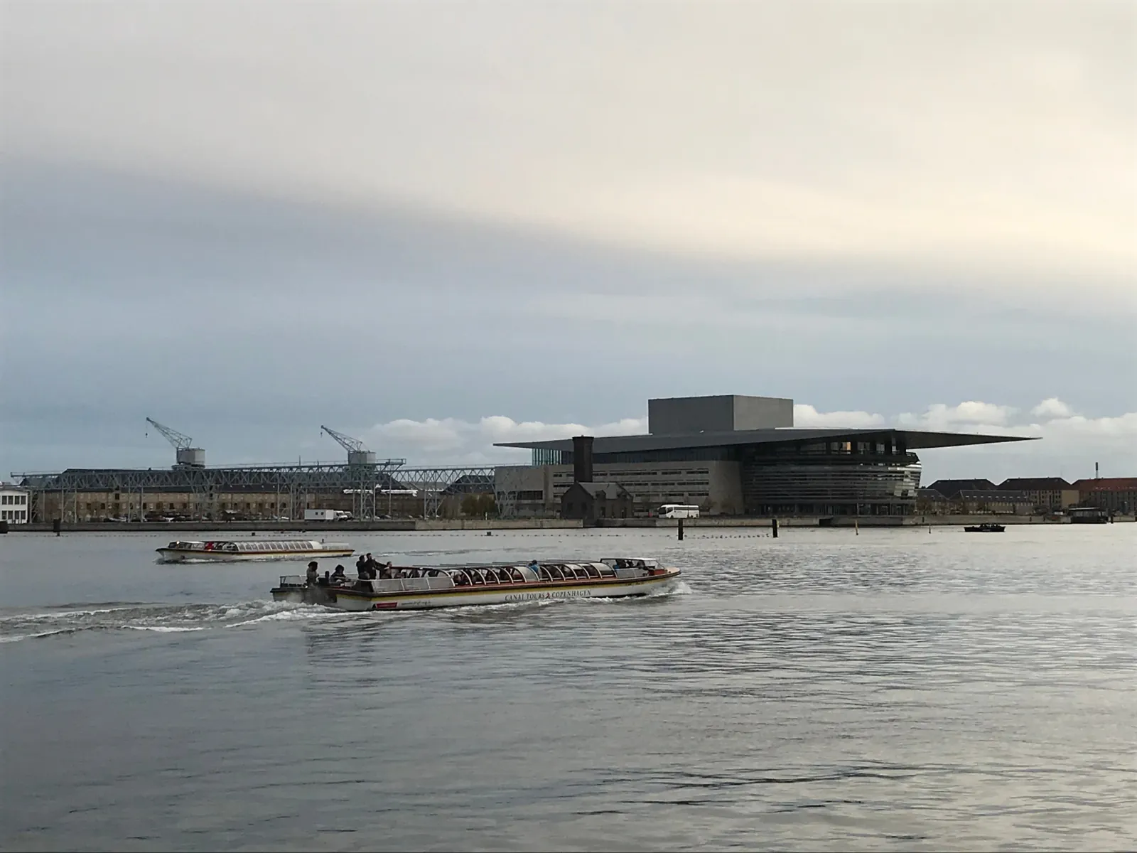 A canal boat in front of the Opera House at dusk
