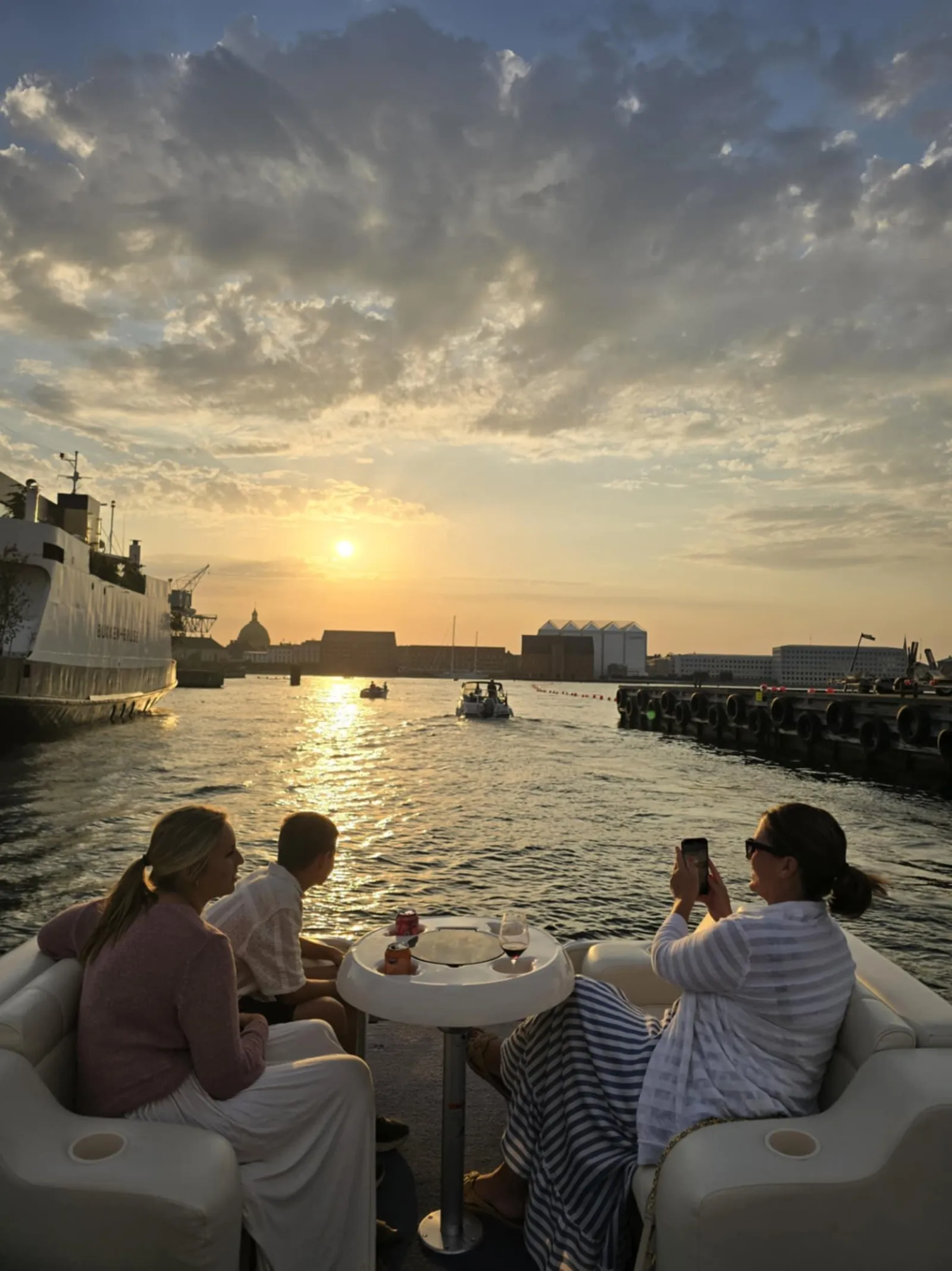 Guests on a private boat watching the sun set over the harbour
