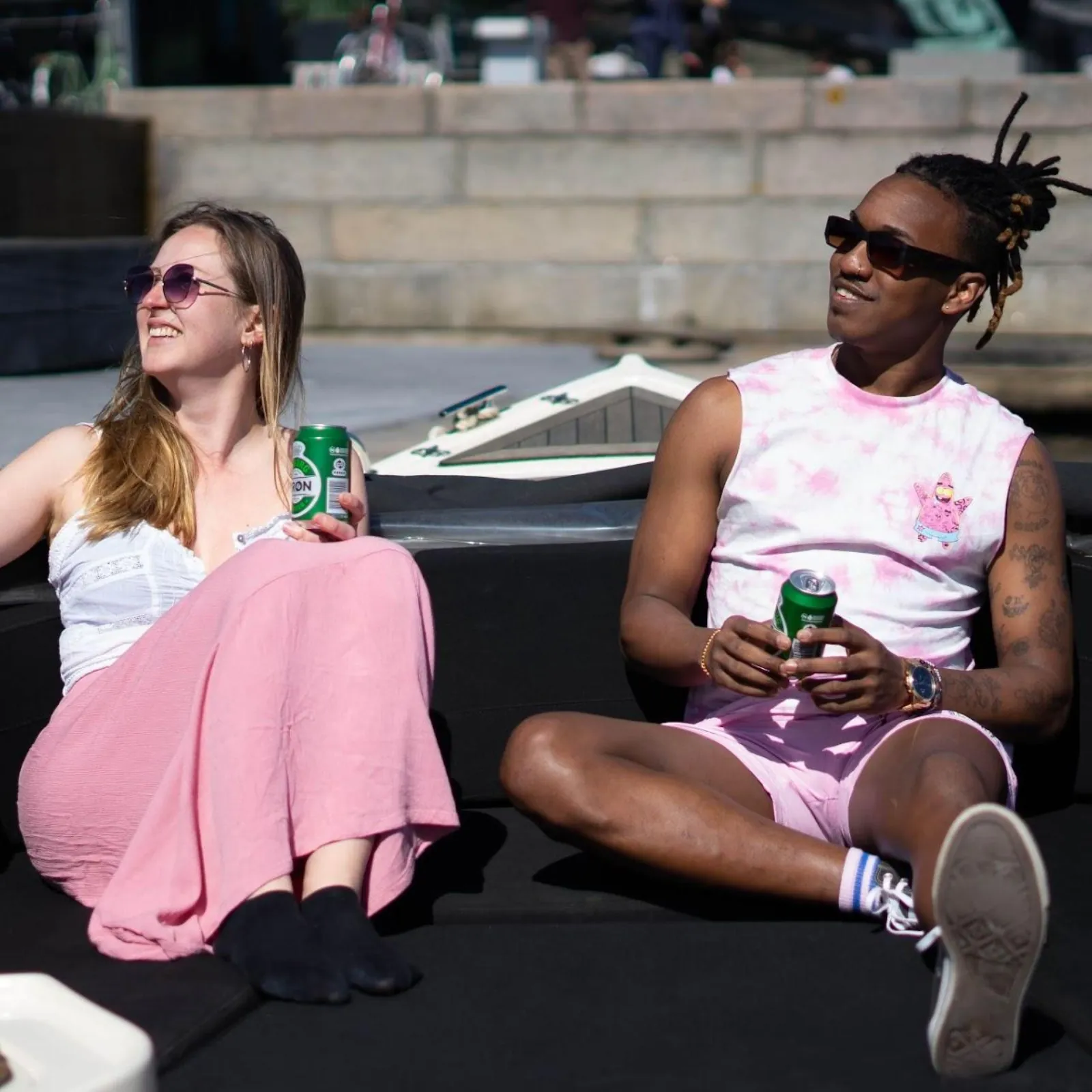 Two guests relaxing on deck with drinks