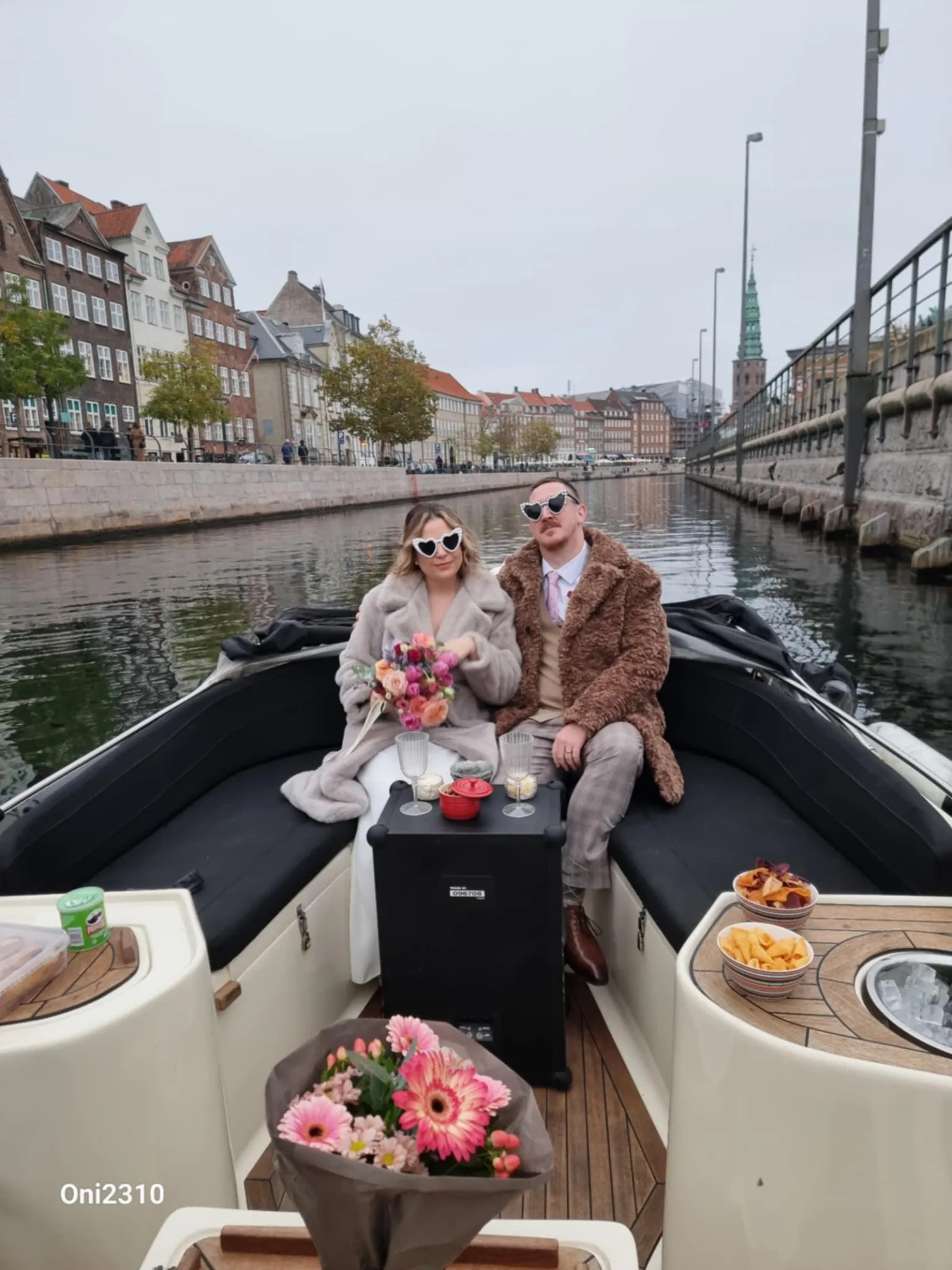 A couple on the private boat in a canal of coloured houses