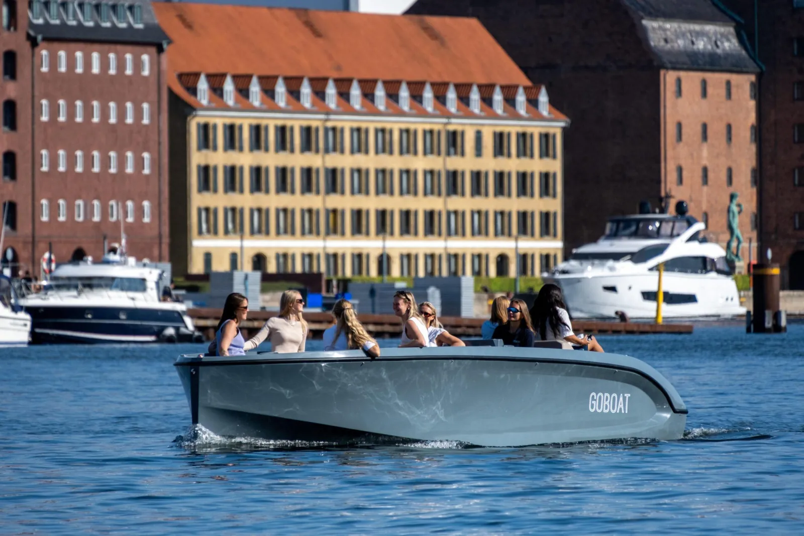 A GoBoat in front of a red-brick waterfront building